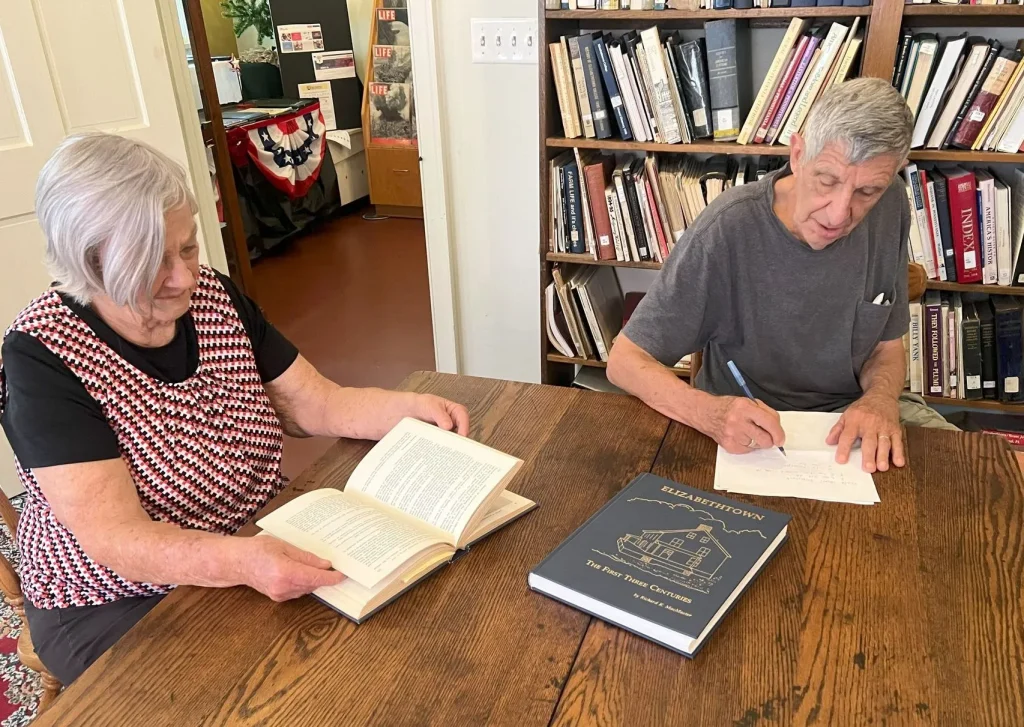 two people utilizing library resources to search geneology